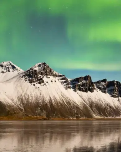 Northern Lights Over Hofn And Mountain Range Iceland.