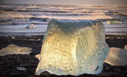 Glowing iceberg at sunset on Diamond Beach near Jökulsárlón Glacier Lagoon, Iceland
