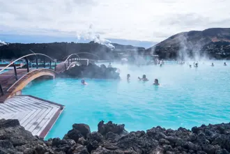 Visitors enjoying the soothing waters of the Blue Lagoon geothermal spa in Iceland, surrounded by volcanic landscapes and misty hot springs.