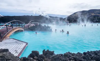 Visitors enjoying the soothing waters of the Blue Lagoon geothermal spa in Iceland, surrounded by volcanic landscapes and misty hot springs.