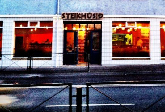 Steikhúsið steakhouse in Reykjavík, Iceland, illuminated in warm tones, showcasing its cozy ambiance and inviting atmosphere during the evening.