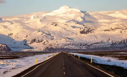 Long road leading to the snow-capped Vatnajökull Glacier in Iceland, captured during a winter sunrise.