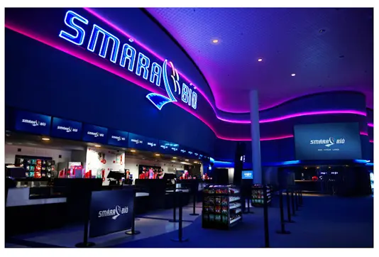 Smárabíó cinema in Reykjavík with vibrant neon lights, showcasing a modern interior for an exceptional movie experience in Iceland.