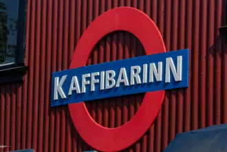 Exterior sign of Kaffibarinn Bar in Reykjavik, featuring its iconic London Underground-inspired logo.
