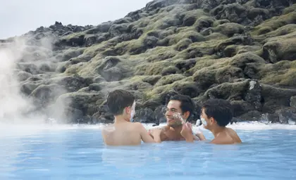 Family enjoying a playful moment in the soothing geothermal waters of the Blue Lagoon, Iceland.