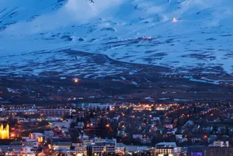 Lights from the town of Akureyri in winter with Hlidarfjall mountain in background.