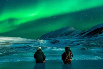 Sitting On Frozen Lake Watching Northern Lights Iceland.
