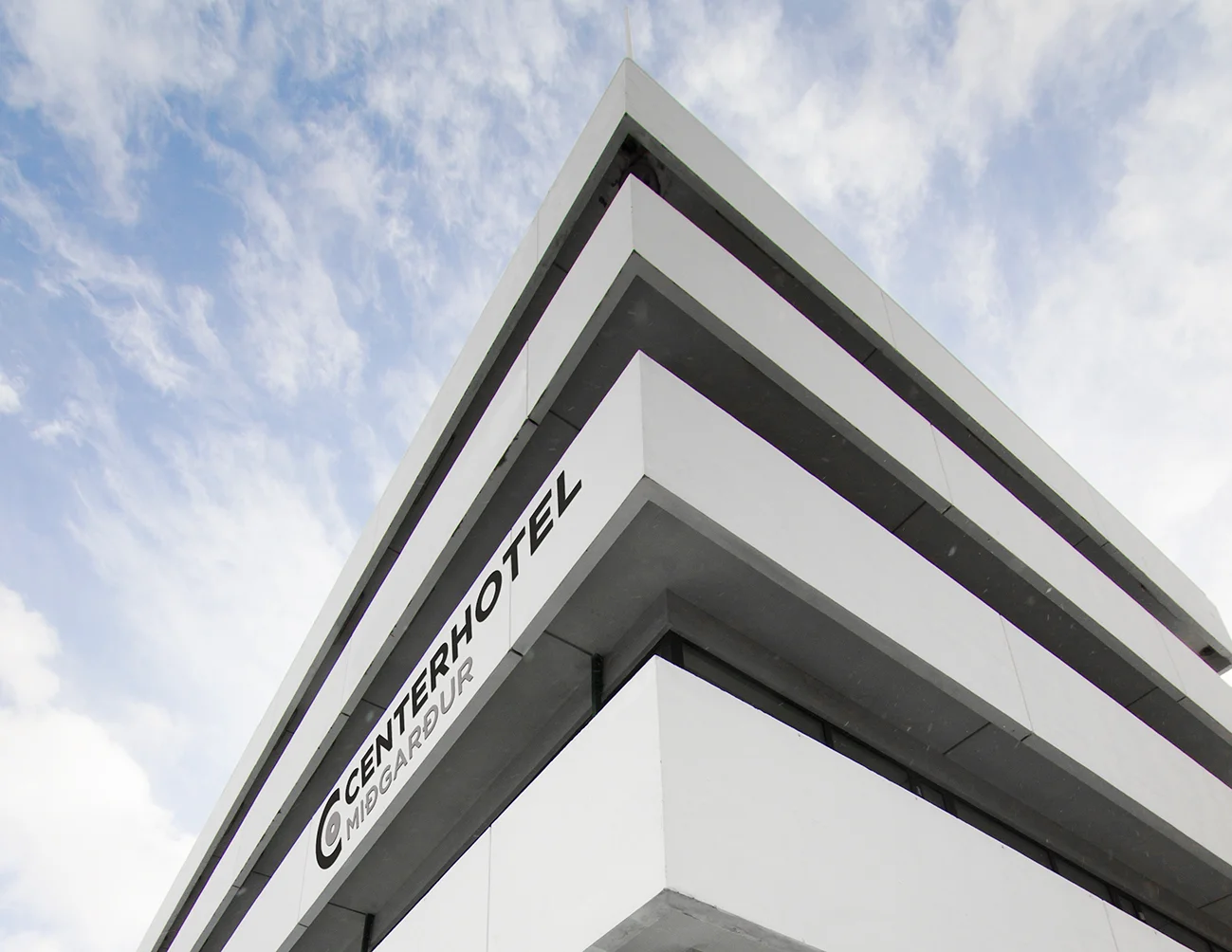 Exterior of Miðgarður hotel in Reykjavík, with the logo showing on the building.