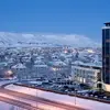 The exterior view of Grand Hótel Reykjavík during winter, with snow-covered surroundings and mountain views.