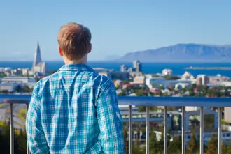 Man in a blue shirt overlooking Reykjavik with Hallgrimskirkja in the background