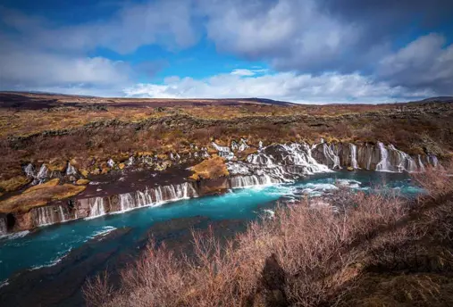 Hraunfossar waterfalls, a stunning series of lava waterfalls in West Iceland, with water cascading from beneath a lava field into the Hvítá river.