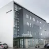 Exterior of Storm Hotel in Reykjavík with modern grey and white façade and parked cars.
