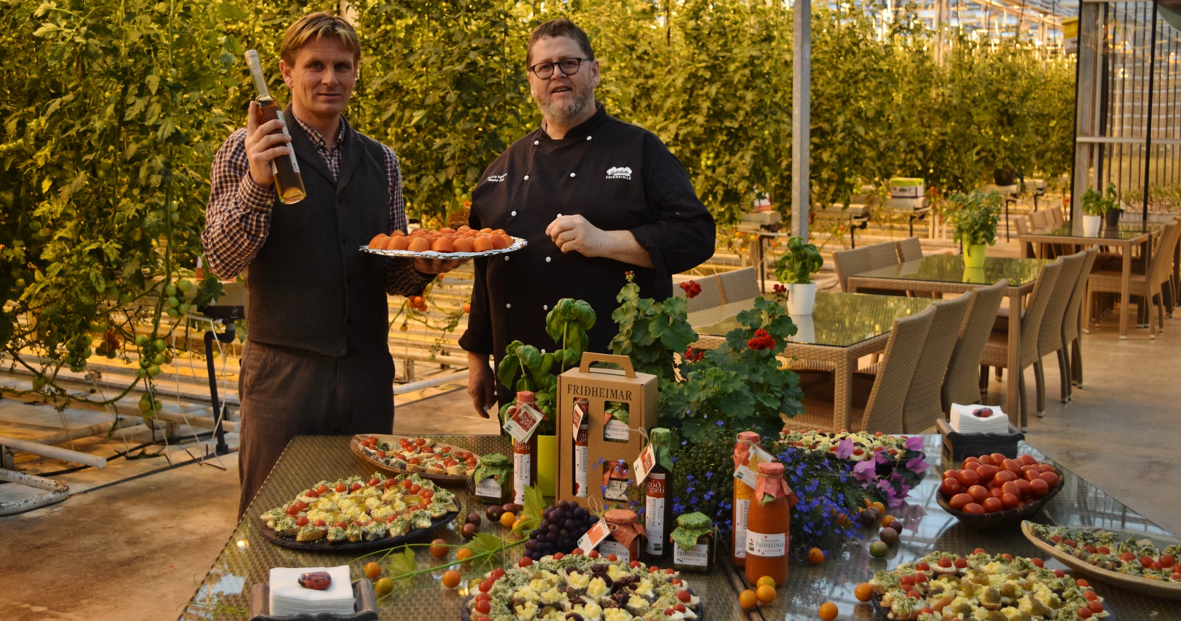Friðheimar tomato farm and restaurant inside the greenhouse with owner and chef presenting tomato dishes.