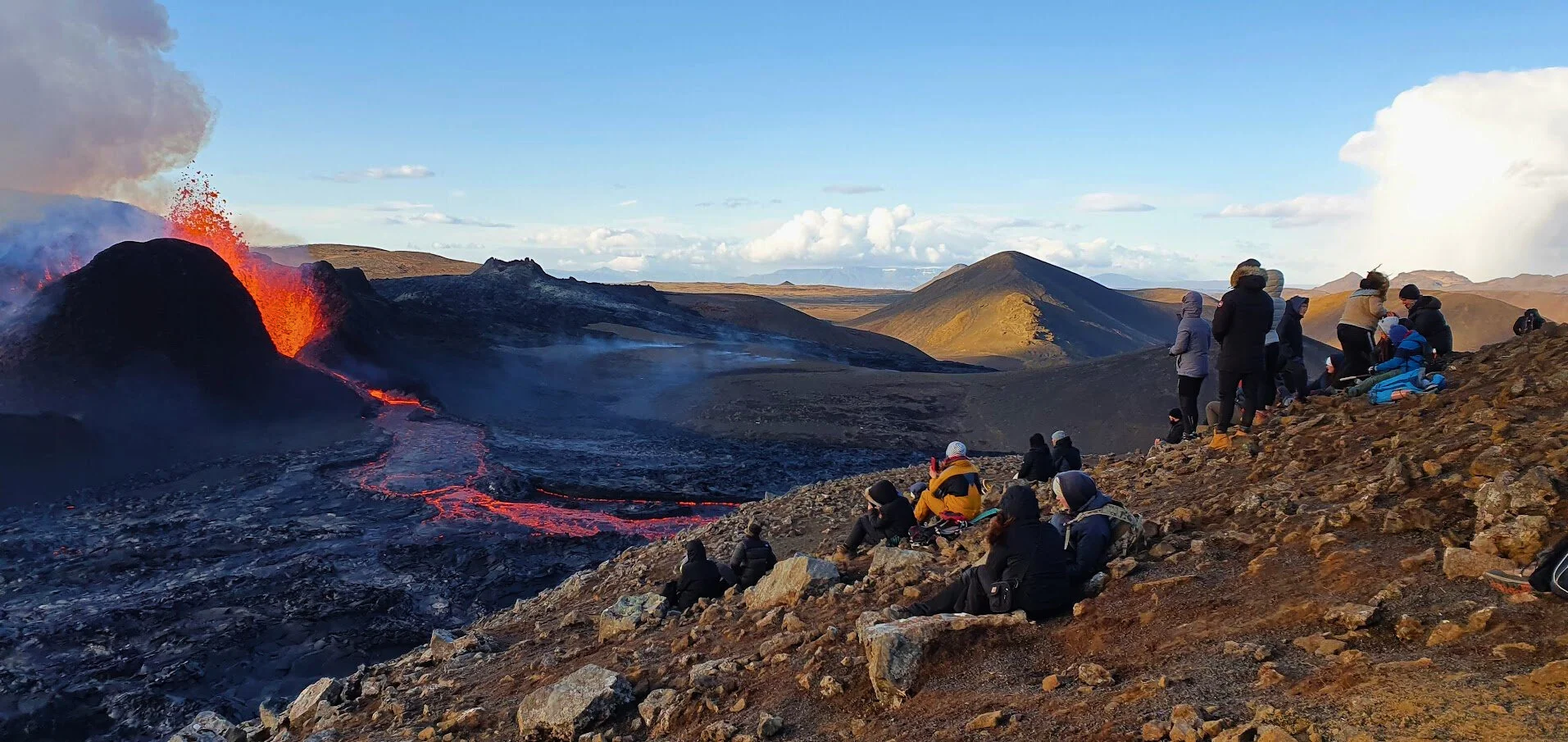 Private Reykjanes Peninsula travelers viewing an active erupting volcano.