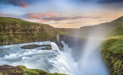 Stunning view of Gullfoss Waterfall at sunset, capturing the mist and cascading water in Iceland's iconic Golden Circle.