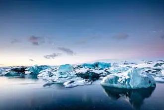 Icebergs floating in the serene waters of Jökulsárlón glacial lagoon in Iceland.