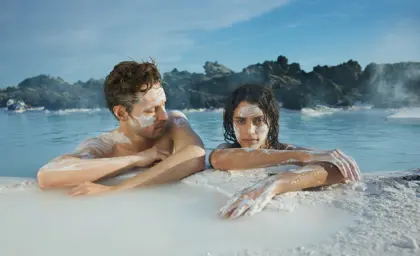 Couple enjoying geothermal spa experience at Blue Lagoon Iceland, applying natural silica face masks for skin rejuvenation.