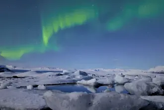 Diamond beach Black Sand Beach under the Northern Lights in Iceland.
