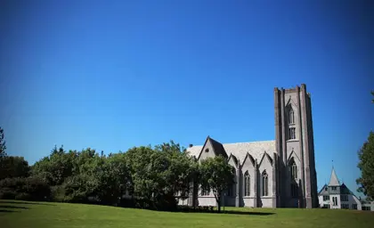 Landakotskirkja, also known as the Cathedral of Christ the King, a Gothic Revival church located in Reykjavík, Iceland, surrounded by greenery.