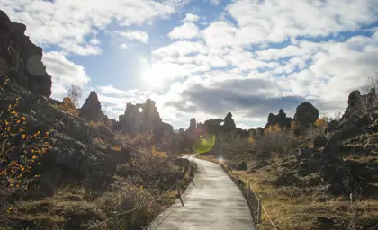 Pathway through lava formations in Dimmuborgir, Mývatn, Iceland, under a bright sky, part of a scenic tour around Iceland with Travel Reykjavik.