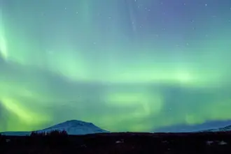 Northern Lights Flowing Over Icelandic Mountains.