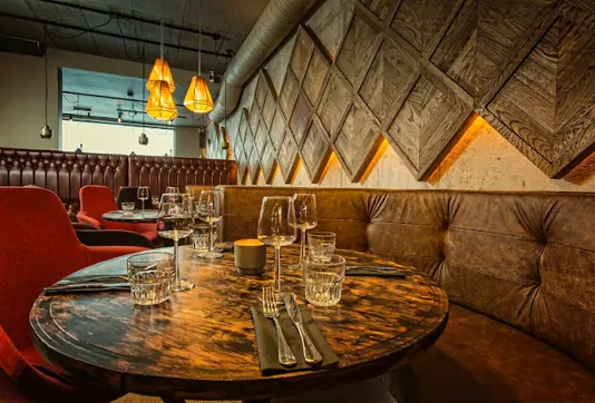 Cozy dining table setup with warm lighting and modern decor at Kol Restaurant, Reykjavík, known for its gourmet Icelandic cuisine and stylish ambiance.